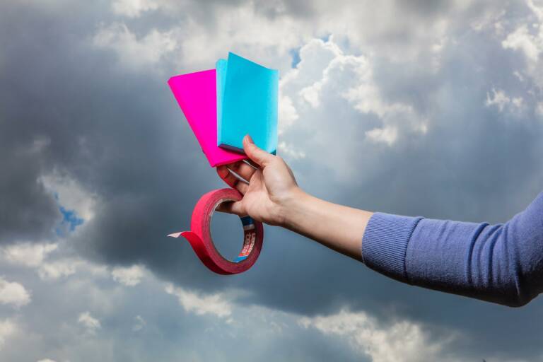 Hand holding post-its and tape