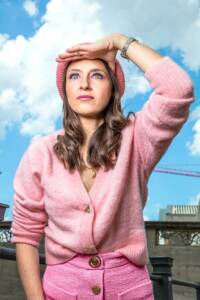 Woman looks into the distance and shields her eyes with her hand