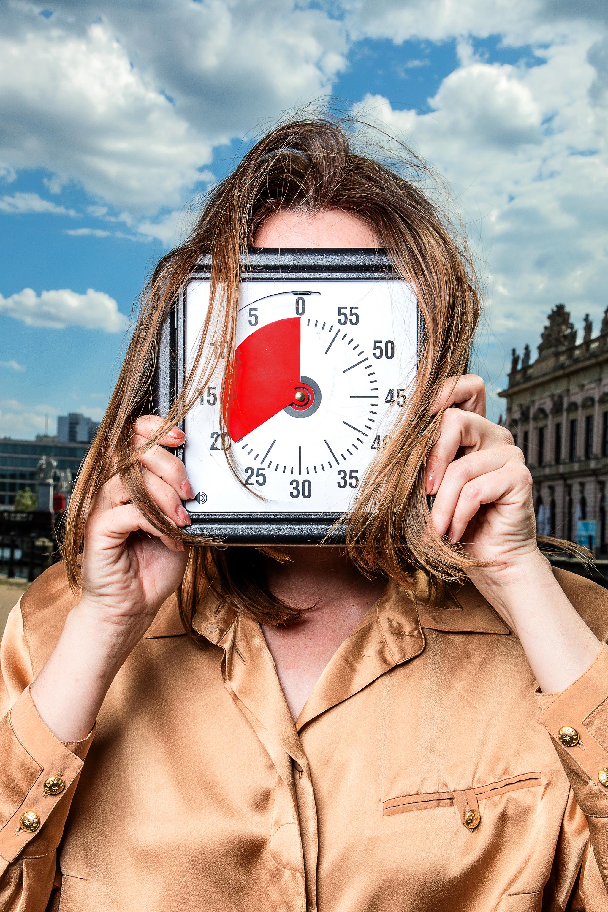 Frau hält Uhr vor ihr Gesicht