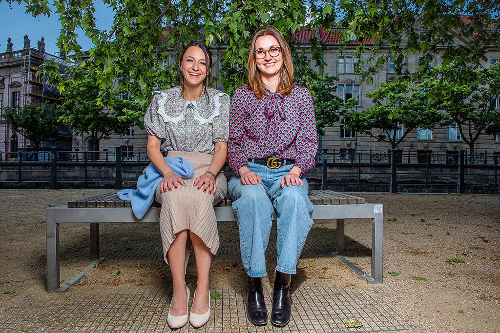 zwei Frauen sitzen nebeneinander auf einer Bank